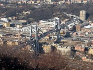 Foto del ponte Morandi a Genova antecedente al tragico crollo. Il ponte, assai trafficato da mezzi pesanti, sovrasta popolosi palazzi.